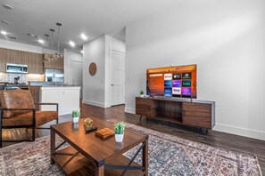 Bright and airy living room with plush seating, a large TV, and tasteful decor, creating the perfect space for relaxation and entertainment.