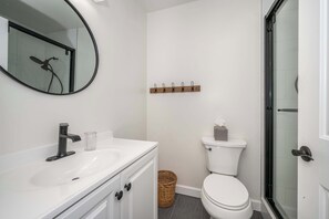 The sleek full bath features a single vanity & shower