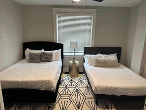 The comfortable bedroom includes 2 queen beds & ceiling fan