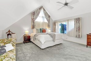 The upstairs primary bedroom offers a comfortable sitting area, dressing table and ensuite bathroom for added privacy.
