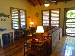 The cozy living area is bright and airy with plenty of lighting and ceiling fan to keep room cool