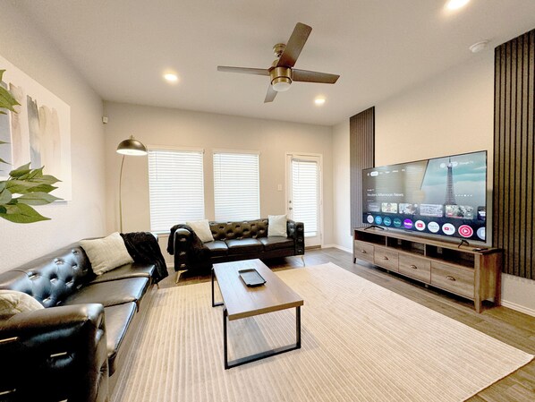 Spacious living room with 75" 4K TV and plenty of seating space
