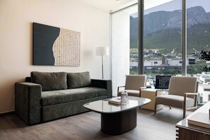 Natural light floods the living room, showcasing comfortable seating and views.
