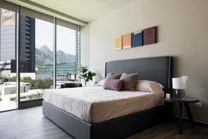 The master bedroom features a plush king-size bed and floor-to-ceiling windows.