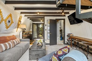 Relax in the cozy living area with  stunning pines, inviting the beauty of the outdoors right inside.