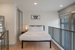 Cozy comfort elevated: A stylish bed nestled in the charm of a loft space.