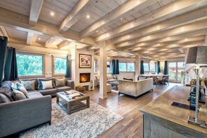 Living area with log burning fire, entertainment system and open plan dining and kitchen. 