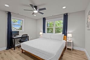 Master bedroom with king bed and cozy workspace for productivity.