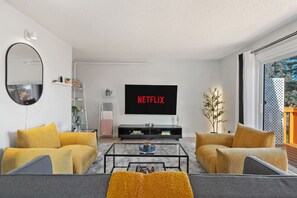Relax in the spacious living room featuring a Futon Sofa Bed with linens provided, a smart TV with Netflix, and a variety of board games for your entertainment.