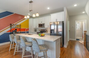 2nd Floor: Fully equipped kitchen stocked with all culinary essentials and stainless steel appliances with an island offering bar seating for 4 guests.