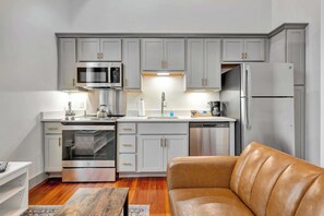 Living Room: Relax in the cozy living space that also offers a modern kitchen with sleek stainless-steel appliances.