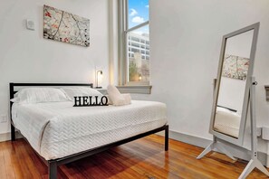 Bedroom: A comfortable bed, bright and open living area with high ceilings, comfortable seating, and stylish decor