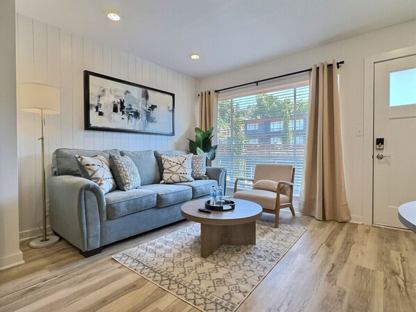 Natural light pours in through large windows, inviting you to unwind after a long day and soak in the comforts of home.