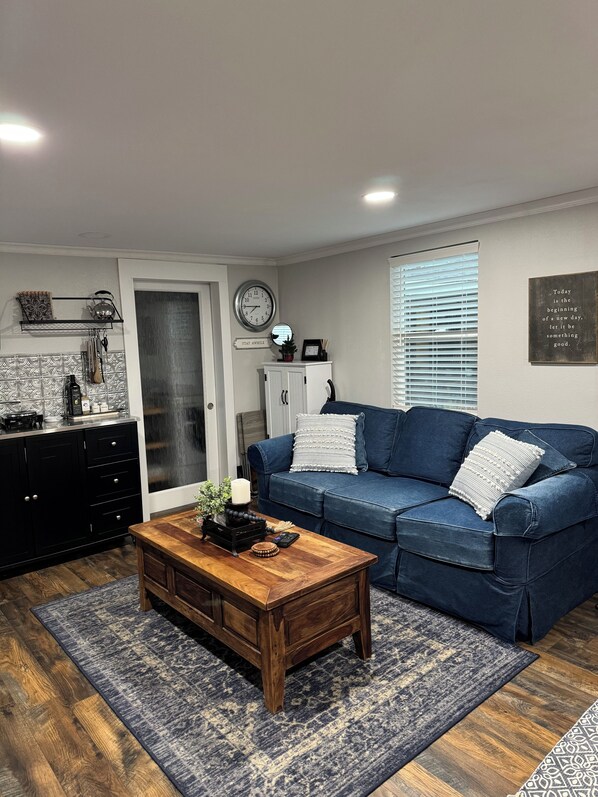 Cozy living room with denim sofa sleeper and a nice large coffee table.