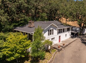 Beautifully landscaped exterior with plenty of open lawn, shaded by trees. 