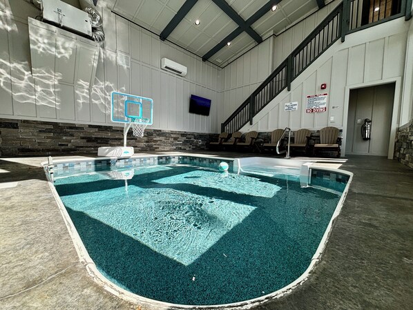 Enjoy a private indoor swimming pool with a basketball hoop, comfy seating