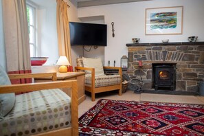 Sitting room with two armchairs and wall mounted TV