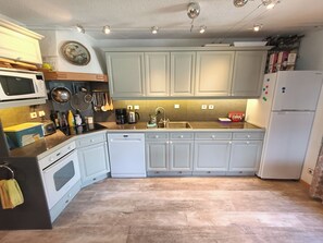 Full kitchen with oven, microwave, fridge-freezer and small appliances.