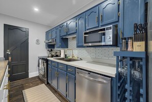 Stunning kitchen with it's blue cupboards and stainless steel appliances!