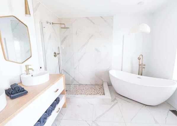 This Master Bedroom ensuite has 2 sinks, stand up shower, a modern freestanding bathtub and toilet!