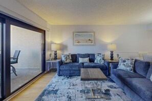 Relax in the cozy living room with easy access to the balcony