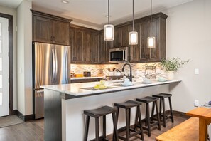 Fully Stocked Chefs Kitchen With An Island That Includes Bar Seating For 4 People
