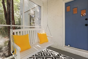 Screened porch with a swing and yellow pillows, perfect for relaxation.