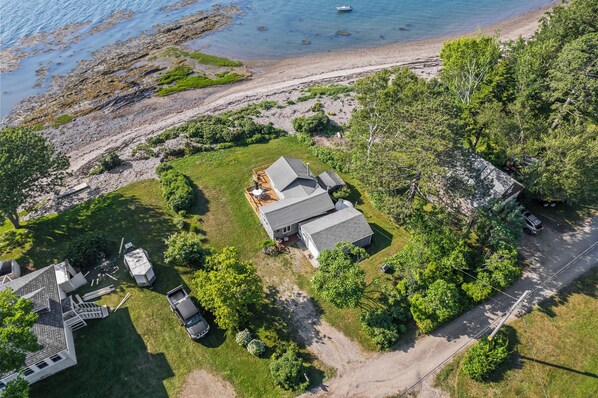 Aerial View of home showing front yard and direct beach access.