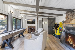 Full game room, with a bar, shuffleboard, arcade games, full kitchenette, fireplace and bedroom!