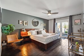Primary bedroom with California King bed, smart TV, large walk-in closet, en-suite bathroom, and private outdoor patio & pool access.