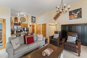 Open-concept living area featuring a mounted TV above a gas fireplace, queen sleeper sofa, and queen Murphy bed.