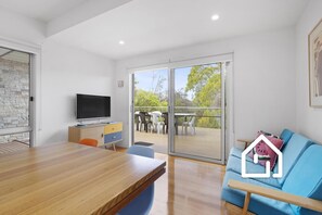 Downstairs open plan living with lounge, smart TV and opens onto the deck