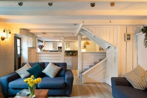 Lounge with sofas, staircase to first floor, kitchen, front door