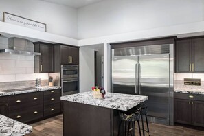 Gourmet kitchen featuring high-end appliances, a commercial-grade refrigerator, and a spacious island perfect for cooking and entertaining.
