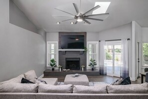 Perfect for cozy movie nights and creating family memories, this spacious living room boasts high ceilings, a Smart TV, and views of the backyard pool.
