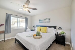 The serene primary bedroom offers a king-size bed & Smart TV