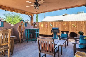 Covered outdoor living with dining area, BBQ, seating and bar. 