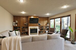 Living room w/ smart TV, convertible movie night sectional & gas fireplace