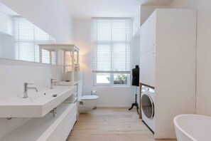 Light filled, neat bathroom with a bathtub