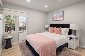 The master bedroom features a comfortable queen bed and a flat screen TV.