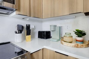 The kitchen is equipped with state-of-the-art appliances, including a Keurig coffee maker.