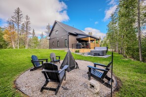 The fire pit area is a great spot for gathering with friends and family, surrounded by lush greenery and scenic views.