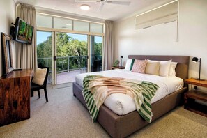 Wake to leafy views in this light-filled primary suite, complete with a king-sized bed, balcony access and a work desk for flexibility.