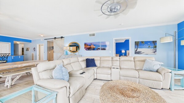 Open concept living area with huge couch and TV