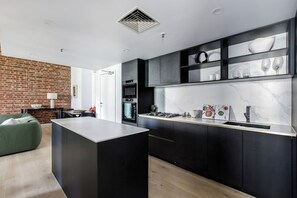 A sleek stone kitchen makes it easy to prepare meals at home with high-end appliances and cooking utensils.
