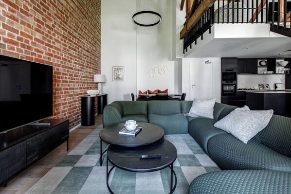 The spacious open-plan living area combines character and style with an oversized sofa to relax after a busy day.
