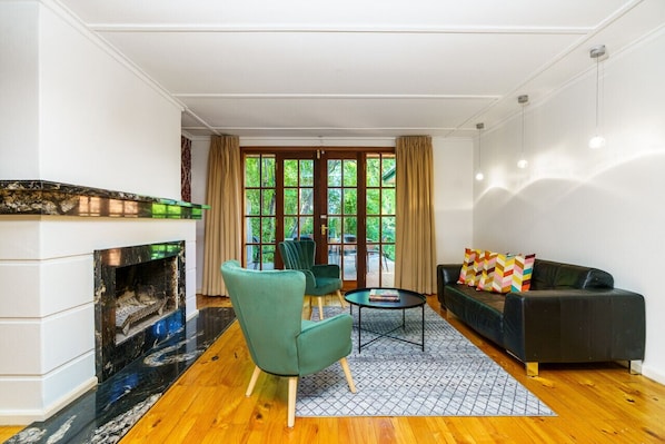 Inviting sitting room with a picturesque view of the backyard, highlighted by a non-functional fireplace that enhances the room's ambiance.