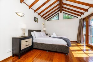 Spacious main bedroom featuring a queen bed adorned with professionally laundered linens for a luxurious touch, a walk-in closet, and direct access to a serene courtyard.