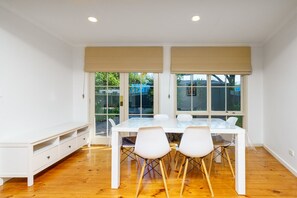 Charming six-seater dining table offering a delightful view of the courtyard, perfect for enjoying meals with family and friends.