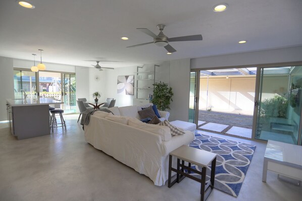 large open concept living area with tow large sliders to outdoor living areas